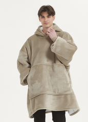 Man wearing oversized khaki hoodie blanket for warmth and comfort.
