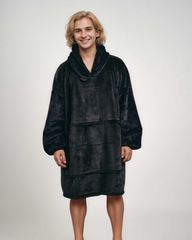 Midnight black SNUGLFIT™ hoodie blanket with plush Sherpa fleece, modeled by a person.