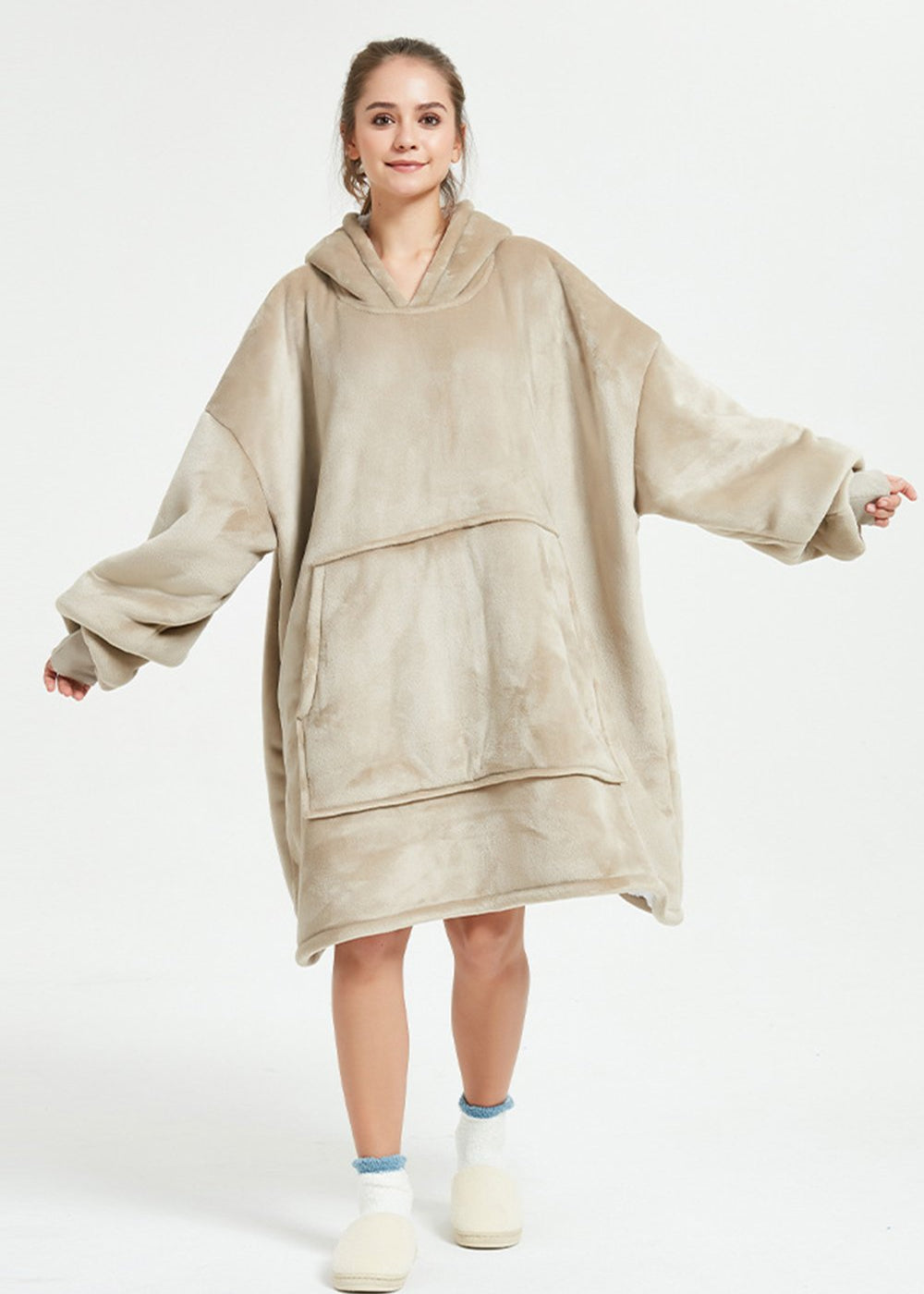 Khaki SnuglFit™ hoodie blanket worn by woman, oversized with large pocket and hood for comfort.