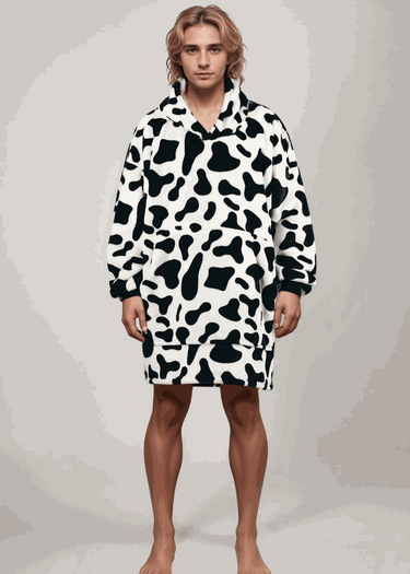 SNUGLFIT™ Hoodie Blanket in cow print design worn by a model showcasing oversized cozy fit.