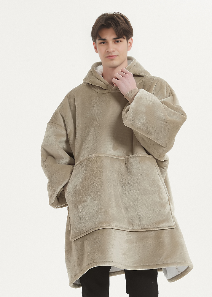 Man wearing oversized khaki hoodie blanket for warmth and comfort.
